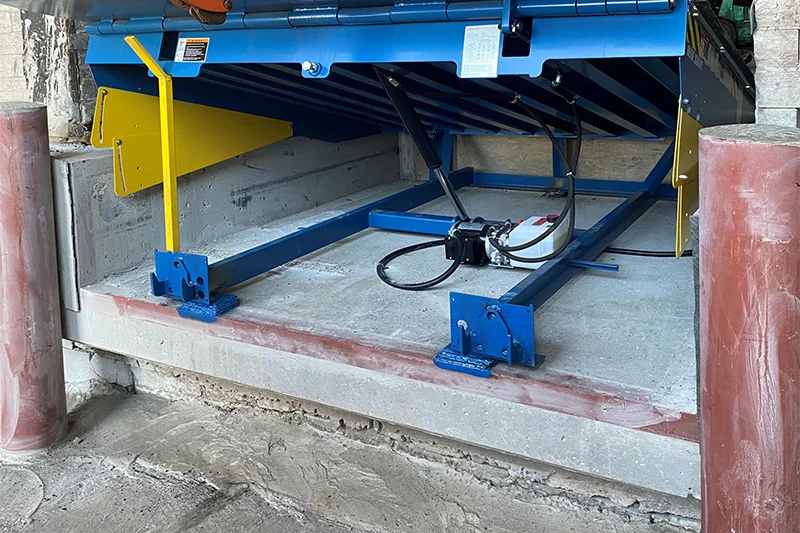 Loading dock hydraulic leveler being serviced.